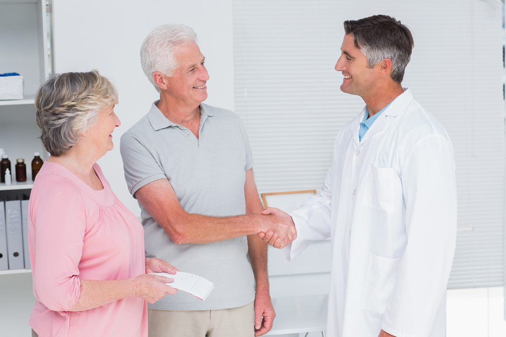 Doctor greets patient and caregiver to improve patient outcomes via caregiver engagement
