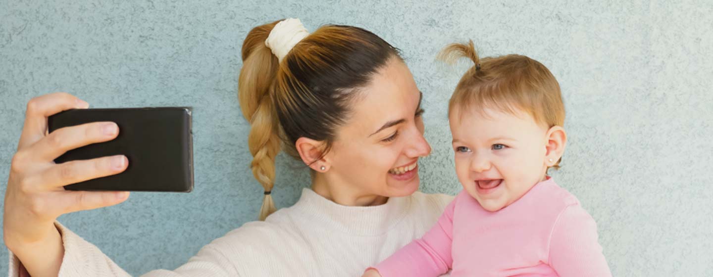 Mother taking selfie with infant daughter